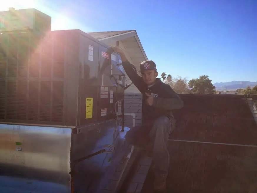 HVAC technician performing AC Tune-Up on a rooftop unit in Tustin